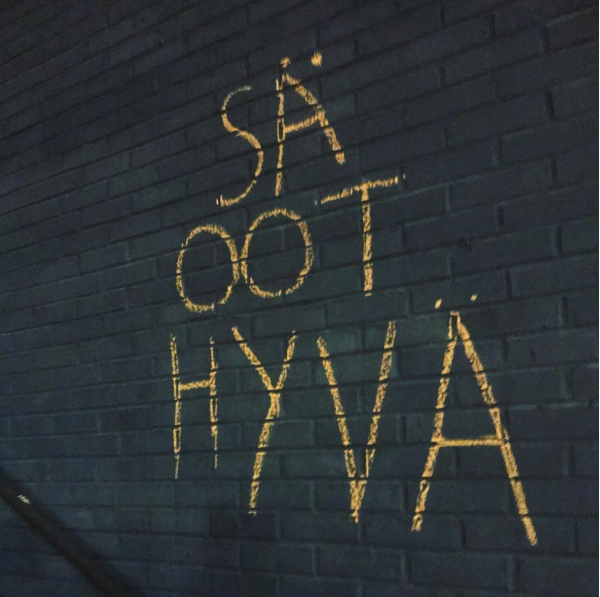 Kuvassa on Anastasia Netrebinen ottama valokuva mustasta tiiliseinästä, johon kirjoitettu keltaisella: